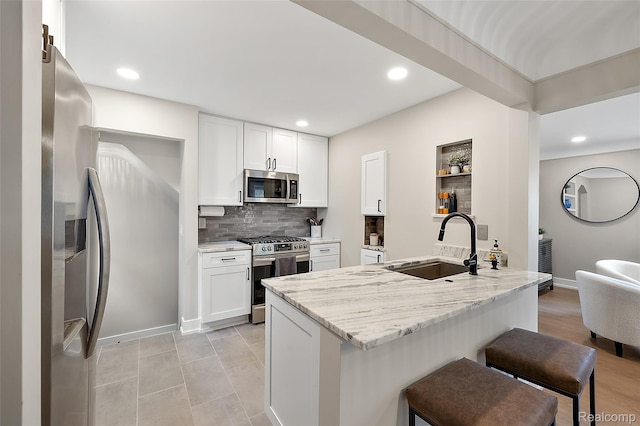10541 Hart Ave, Huntington Woods, MI 48070 - kitchen featuring appliances with stainless steel finishes, a peninsula, a breakfast bar area, a sink, and backsplash
