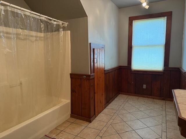 285 Scott St, Newaygo, MI 49337 - full bathroom featuring tile patterned flooring, wainscoting, shower / tub combo, and wooden walls