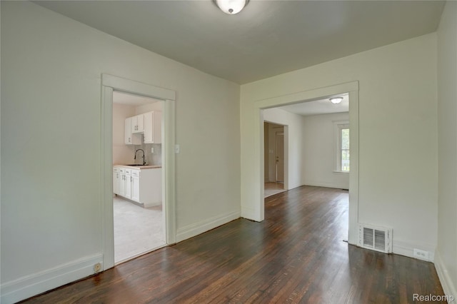 8103 E Canfield St, Detroit, MI 48214 - spare room featuring a sink, dark wood-style flooring, and baseboards