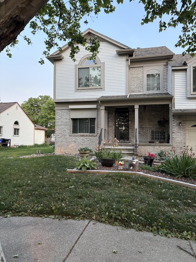 1664 Estates Dr, Detroit, MI 48206 - view of front of house featuring a porch, brick siding, and a front yard