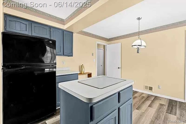 29146 W Wellington Unit 83, Southfield, MI 48034 - kitchen featuring freestanding refrigerator, blue cabinets, light countertops, wood finished floors, and hanging light fixtures