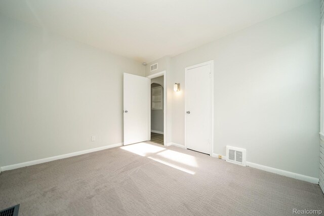 967 Keith St, Oxford, MI 48371 - unfurnished bedroom featuring carpet floors, baseboards, and arched walkways
