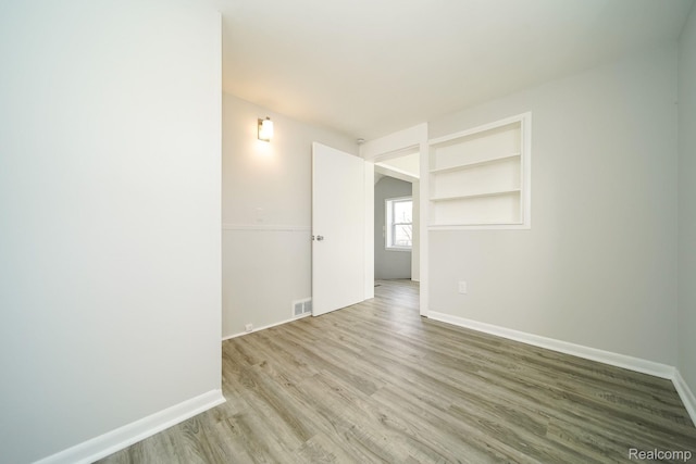 967 Keith St, Oxford, MI 48371 - spare room with wood finished floors, baseboards, and built in features