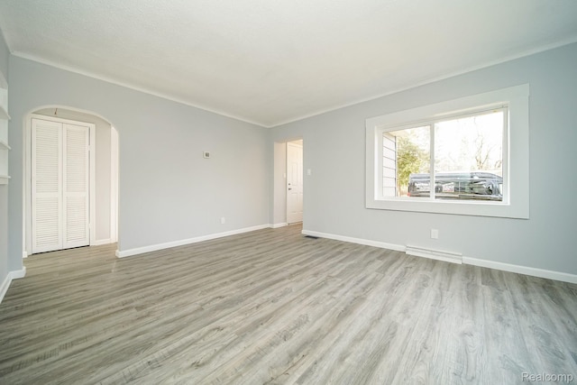 967 Keith St, Oxford, MI 48371 - unfurnished room with arched walkways, wood finished floors, and baseboards