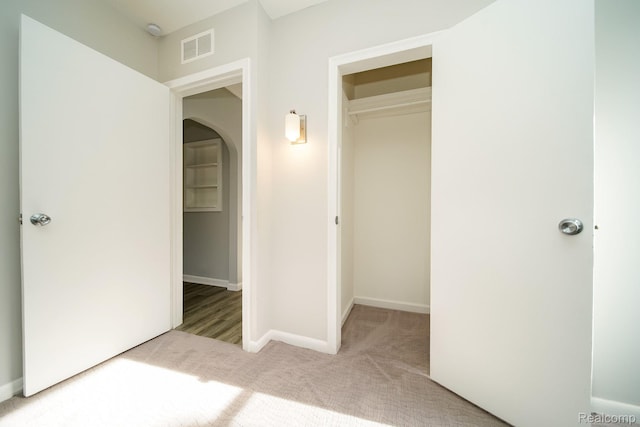 967 Keith St, Oxford, MI 48371 - unfurnished bedroom featuring carpet, a closet, baseboards, arched walkways, and a spacious closet