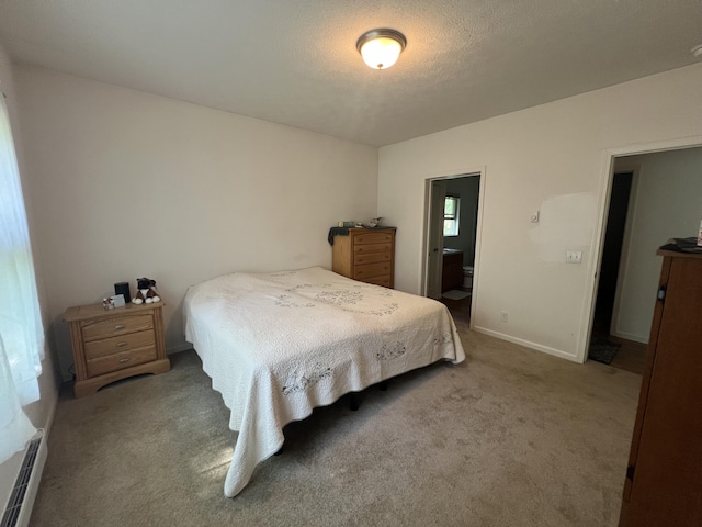 252 E Fenn Rd, Coldwater, MI 49036 - carpeted bedroom featuring a baseboard radiator, baseboards, ensuite bath, and a textured ceiling