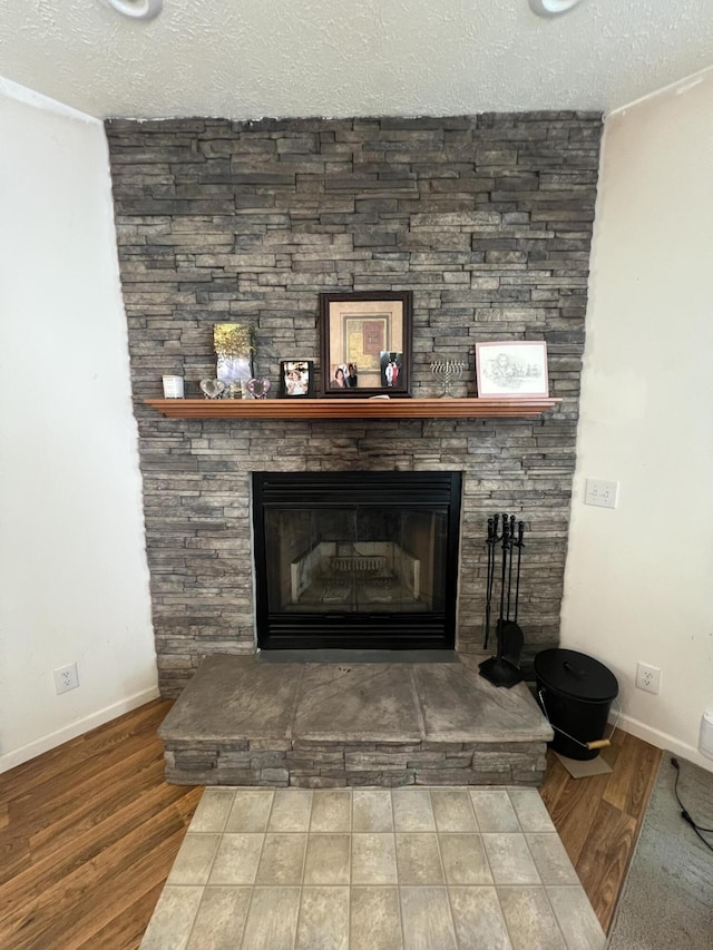 252 E Fenn Rd, Coldwater, MI 49036 - detailed view of wood finished floors, a textured ceiling, baseboards, and a stone fireplace