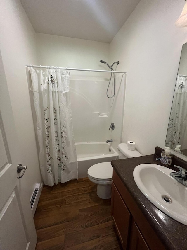 252 E Fenn Rd, Coldwater, MI 49036 - bathroom featuring vanity, a baseboard radiator, wood finished floors, shower / tub combo with curtain, and toilet