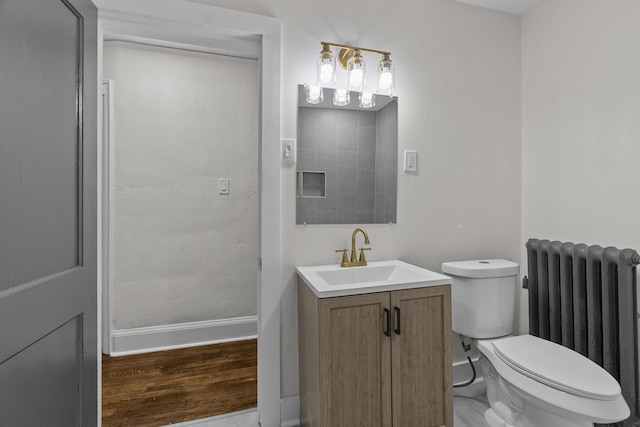 16631 Lawton St, Detroit, MI 48221 - bathroom with radiator, baseboards, vanity, toilet, and wood finished floors