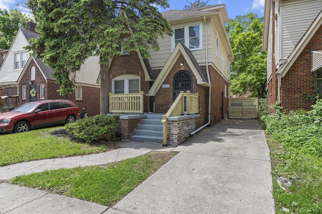 16631 Lawton St, Detroit, MI 48221 - tudor house with brick siding, concrete driveway, and a shingled roof