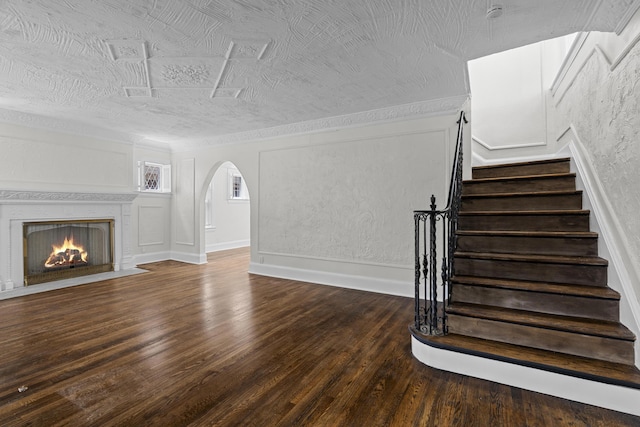 16631 Lawton St, Detroit, MI 48221 - stairs featuring arched walkways, wood finished floors, and a fireplace with flush hearth