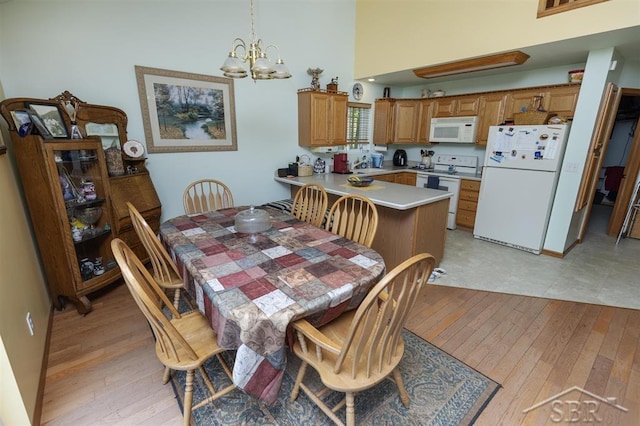 3485 Lakeshore Dr, Lupton, MI 48635 - dining space featuring light wood-style floors, a chandelier, and a high ceiling