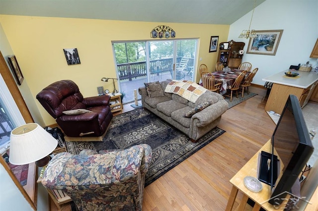3485 Lakeshore Dr, Lupton, MI 48635 - living room with lofted ceiling, wood finished floors, and a chandelier