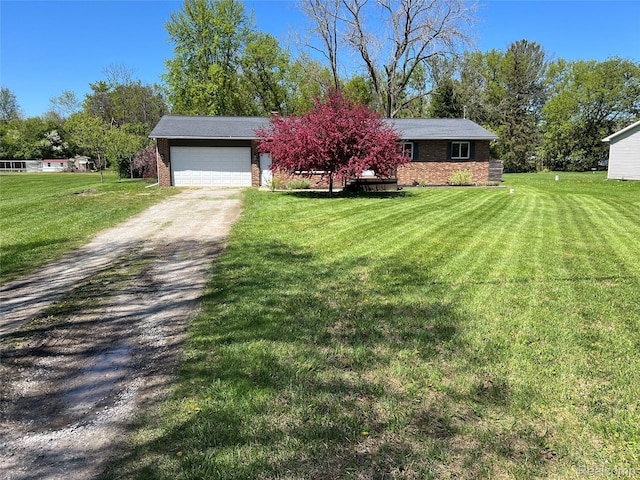 5327 E Carpenter Rd, Grand Blanc, MI 48506 - view of front of house with driveway, brick siding, a front yard, and a garage