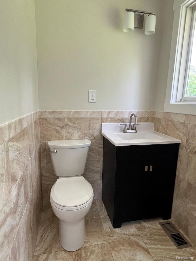 5327 E Carpenter Rd, Grand Blanc, MI 48506 - half bathroom featuring tile walls, vanity, and a wainscoted wall