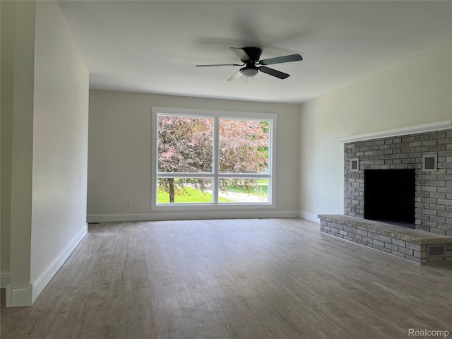 5327 E Carpenter Rd, Grand Blanc, MI 48506 - unfurnished living room featuring wood finished floors, ceiling fan, and a brick fireplace