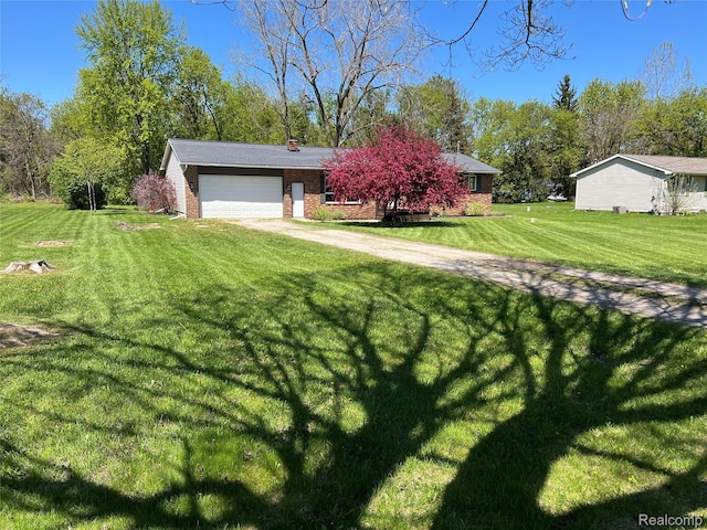 5327 E Carpenter Rd, Grand Blanc, MI 48506 - view of front of house featuring a front lawn, an attached garage, brick siding, driveway, and a chimney