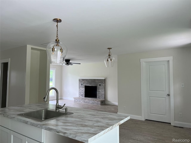 5327 E Carpenter Rd, Grand Blanc, MI 48506 - kitchen featuring light countertops, pendant lighting, a ceiling fan, a fireplace, and white cabinetry