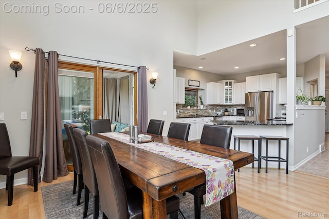 4118 Shoreview Ln, Whitmore Lake, MI 48189 - dining room with light wood-style floors, a towering ceiling, recessed lighting, and baseboards
