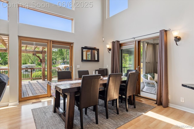 4118 Shoreview Ln, Whitmore Lake, MI 48189 - dining area with wood finished floors, a towering ceiling, and baseboards