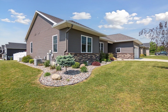 10 Windswept Ln, Hillsdale, MI 49242 - view of front facade with a garage, stone siding, driveway, central air condition unit, and a shingled roof