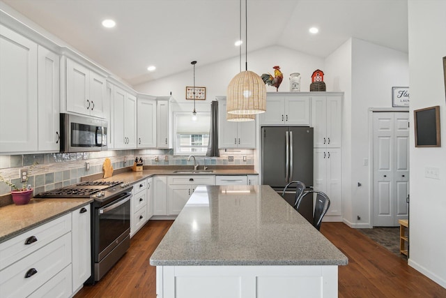 10 Windswept Ln, Hillsdale, MI 49242 - kitchen featuring stainless steel appliances, a sink, a kitchen island, backsplash, and lofted ceiling