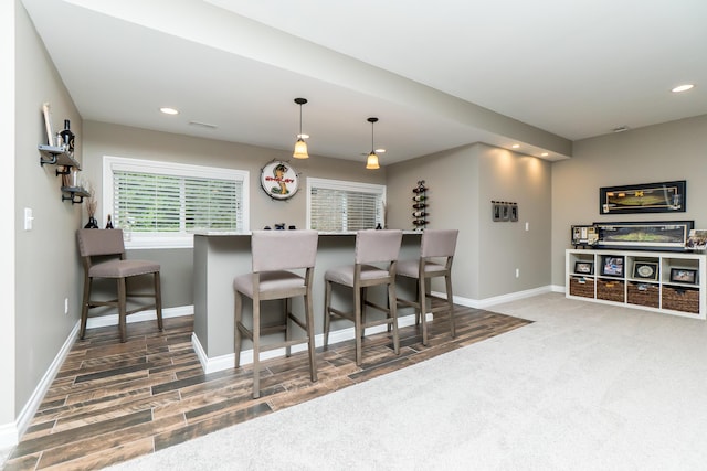 133 E Auburn Trl, Brighton, MI 48114 - kitchen featuring recessed lighting, baseboards, hanging light fixtures, a kitchen bar, and carpet flooring