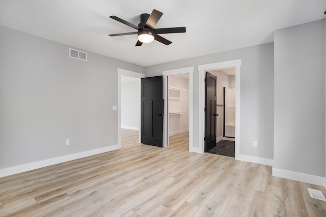 6646 E Eagle Lake Dr, Kalamazoo, MI 49009 - unfurnished bedroom featuring a walk in closet, light wood-style floors, baseboards, and a closet