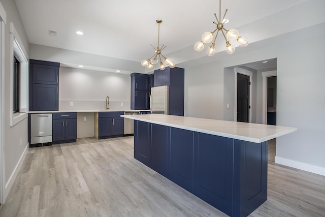 6646 E Eagle Lake Dr, Kalamazoo, MI 49009 - kitchen featuring freestanding refrigerator, blue cabinets, dishwasher, a chandelier, and light wood-style flooring