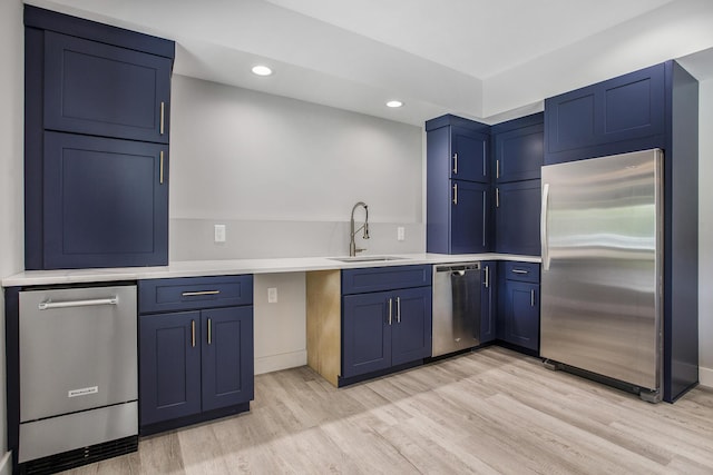 6646 E Eagle Lake Dr, Kalamazoo, MI 49009 - kitchen with appliances with stainless steel finishes, a sink, blue cabinets, light wood-style floors, and recessed lighting
