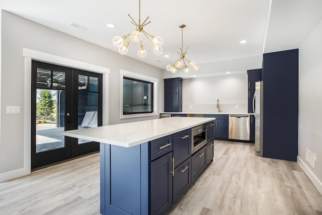 6646 E Eagle Lake Dr, Kalamazoo, MI 49009 - kitchen with appliances with stainless steel finishes, a chandelier, light wood-style floors, a sink, and blue cabinetry