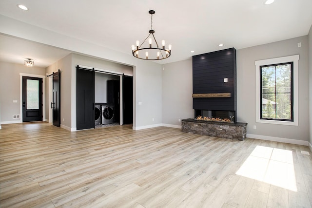 6646 E Eagle Lake Dr, Kalamazoo, MI 49009 - unfurnished living room featuring washer and dryer, a barn door, light wood-style floors, baseboards, and recessed lighting
