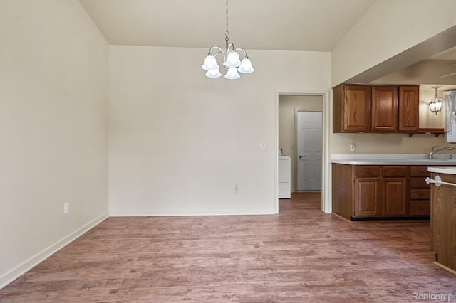 13716 Maple Grove Ave, Shelby Twp, MI 48315 - kitchen with light wood-style flooring, a chandelier, light countertops, a sink, and hanging light fixtures