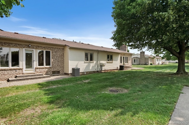 13716 Maple Grove Ave, Shelby Twp, MI 48315 - rear view of house with entry steps, a yard, brick siding, a chimney, and cooling unit