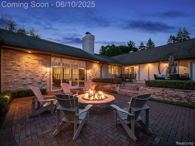 530 E Long Lake Rd, Bloomfield Hills, MI 48304 - patio terrace at dusk featuring an outdoor fire pit, a patio area, and french doors
