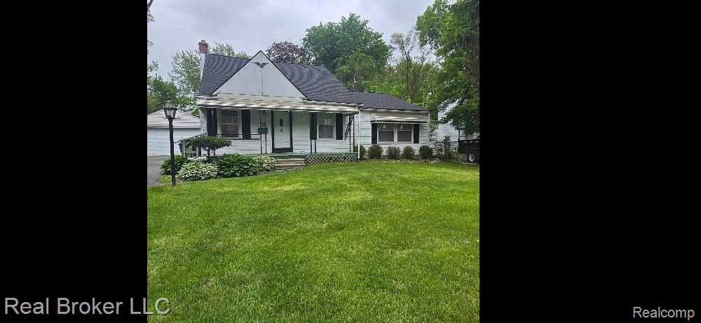 31749 Rosslyn Ave, Garden City, MI 48135 - view of front facade featuring a front yard, a chimney, a garage, and an outdoor structure