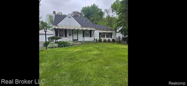 31749 Rosslyn Ave, Garden City, MI 48135 - view of front facade featuring a front yard, a chimney, a garage, and an outdoor structure