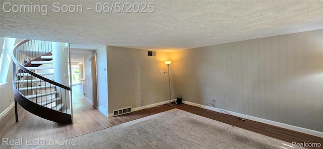 3825 Thomas Rd, Oxford, MI 48371 - unfurnished room featuring a textured ceiling, wood finished floors, baseboards, and stairs