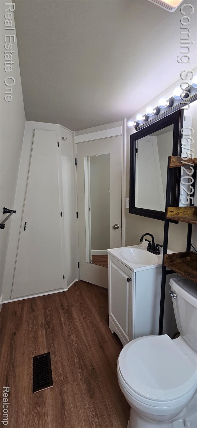 3825 Thomas Rd, Oxford, MI 48371 - half bathroom featuring wood finished floors, toilet, and vanity