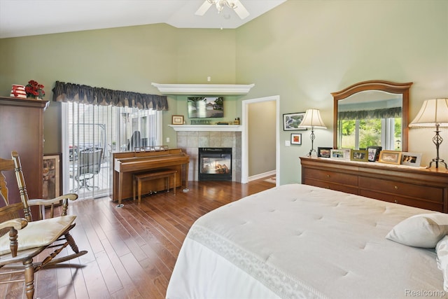 10172 Clarkshire Ct, South Lyon, MI 48178 - bedroom featuring access to exterior, a tiled fireplace, high vaulted ceiling, and wood finished floors
