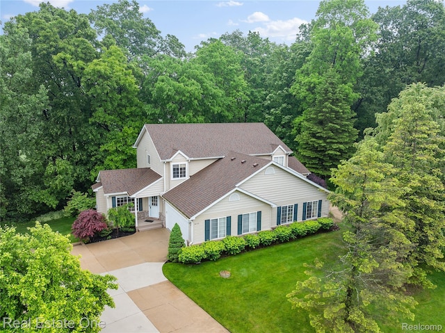 8859 Redstone Dr, Pinckney, MI 48169 - traditional-style house featuring driveway, a front yard, a shingled roof, and a garage