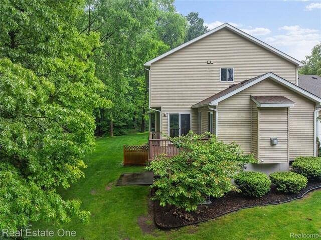8859 Redstone Dr, Pinckney, MI 48169 - rear view of property featuring a wooden deck and a yard