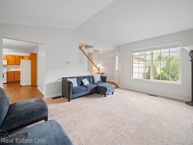 8859 Redstone Dr, Pinckney, MI 48169 - living room featuring stairway, baseboards, vaulted ceiling, and carpet floors