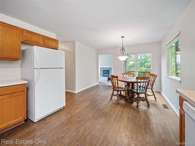 8859 Redstone Dr, Pinckney, MI 48169 - dining space with wood finished floors, a stone fireplace, and baseboards