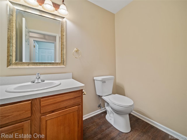 8859 Redstone Dr, Pinckney, MI 48169 - bathroom featuring baseboards, toilet, vanity, and wood finished floors