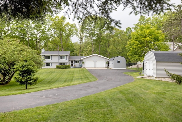 66 Meridian Ct, Mount Pleasant, MI 48858 - view of front of property featuring a chimney, a front lawn, a gambrel roof, and driveway