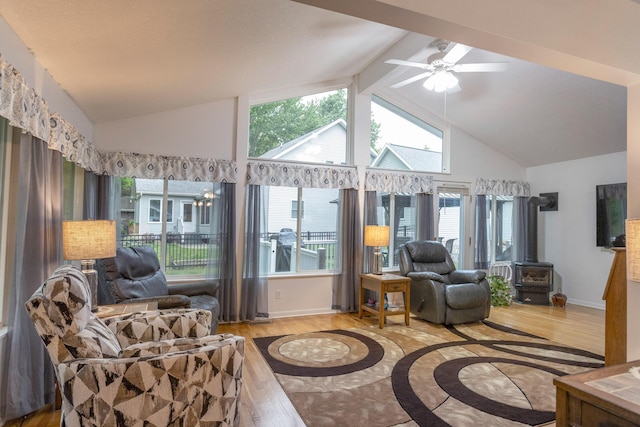 66 Meridian Ct, Mount Pleasant, MI 48858 - living room with wood finished floors, a wood stove, a ceiling fan, beamed ceiling, and baseboards