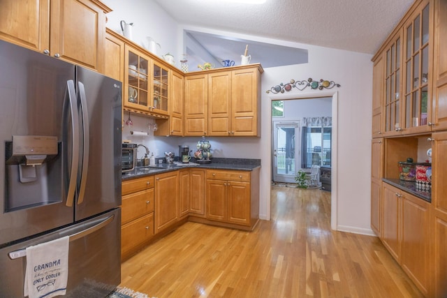 66 Meridian Ct, Mount Pleasant, MI 48858 - kitchen with stainless steel fridge with ice dispenser, light wood-style floors, vaulted ceiling, glass insert cabinets, and brown cabinetry