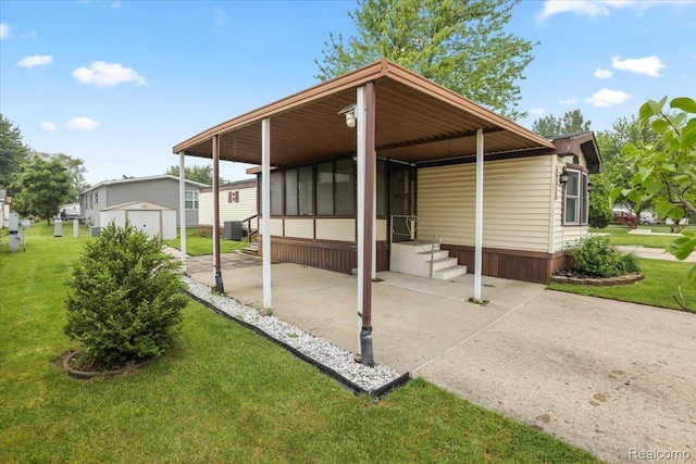 49831 Leicester Ct, Shelby Twp, MI 48315 - rear view of property featuring a lawn, an outbuilding, central AC unit, a sunroom, and a carport