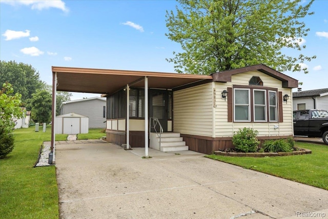 49831 Leicester Ct, Shelby Twp, MI 48315 - manufactured / mobile home with concrete driveway, a front yard, a carport, and entry steps